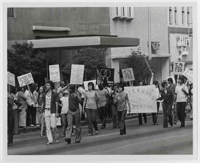 A black and white photo from 1972 of people holding signs and marching down the street.