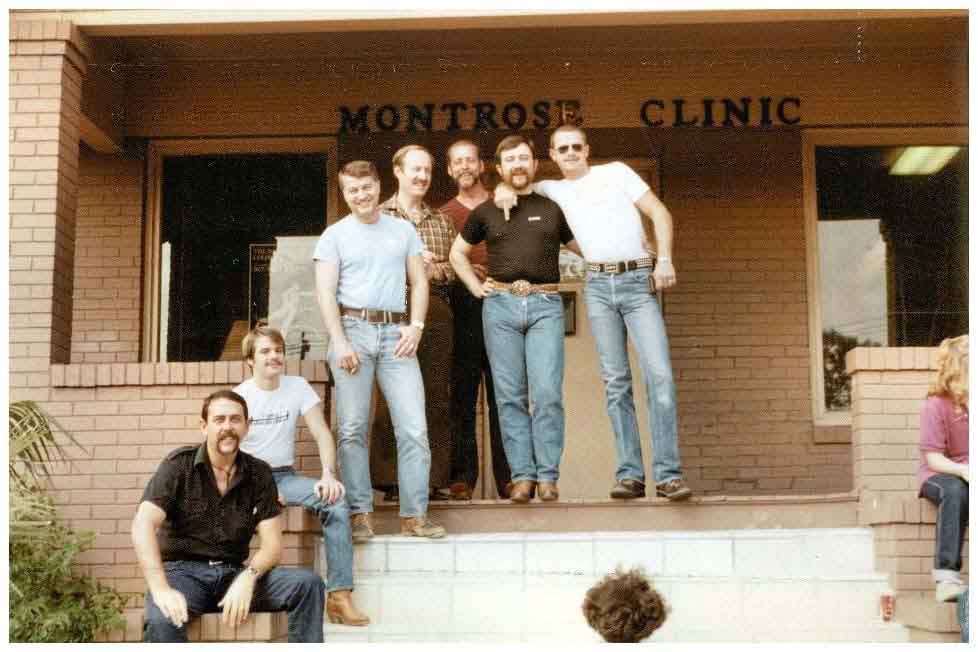 A color photo from 1981 of 7 men gathered outside the a building called Montrose Clinic.